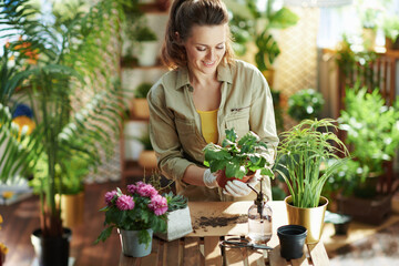 smiling woman in rubber gloves in sunny day do gardening