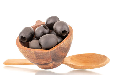 A few pickled black olives in a wooden bowl with a wooden spoon, macro, isolated on white.