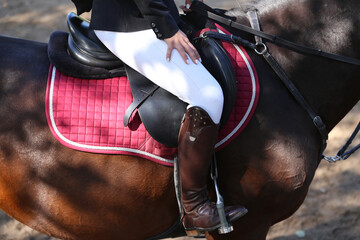 Unknown dressage rider sits on her sport horse during race
