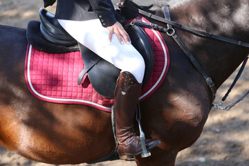 Unknown dressage rider sits on her sport horse during race
