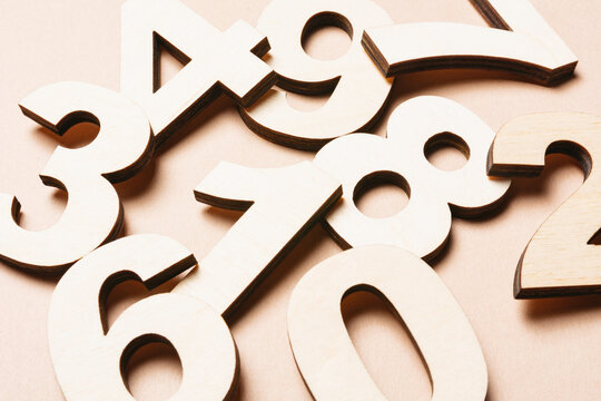 Studio shot of pile of assorted numbers against beige background