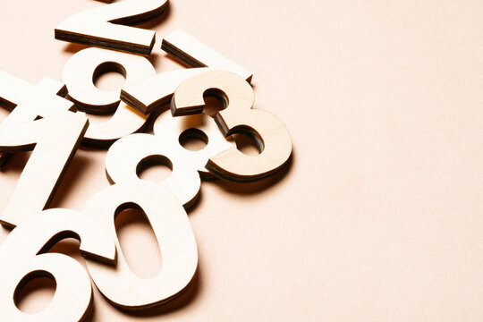 Studio shot of pile of assorted numbers against beige background