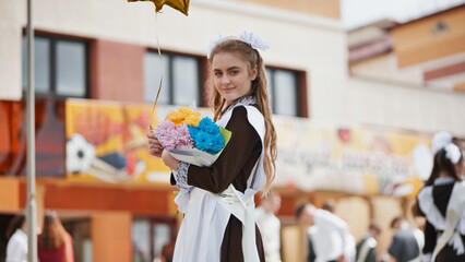 Happy Russian schoolgirl on the last day of school with balloons.