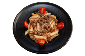 Penne with meatballs on a black plate