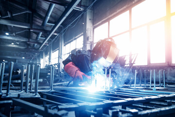 Factory industry worker welder in protective uniform with mask on workplace metalwork