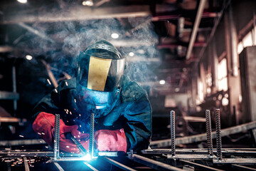 Factory industry worker welder in protective uniform with mask on workplace metalwork