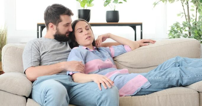 Couple spending leisure time on sofa at home