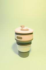 Reusable silicone cup for coffee on a light background. Vertical photo