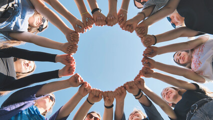 A group of girls makes a circle from their fists of their hands.