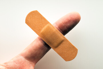 Medical disposable adhesive plaster on the index finger of a person. First aid for injuries