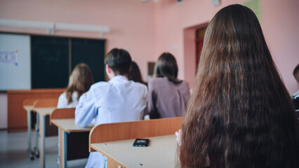 Pupils of the 11th grade in the class at the desks during the lesson. Russian school.