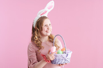 happy stylish child with long wavy blond hair on pink