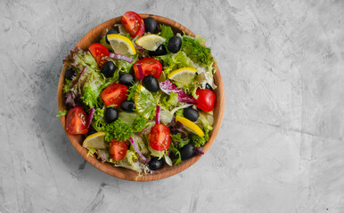 lettuce leaves, tomato, olives in a plate close-up