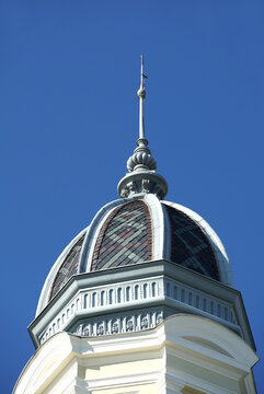 The top of the tower is covered with colorful roof tiles and a lightning rod on top