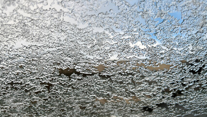 Frozen car windshield, ice on the glass, snowflakes of snow, icing.