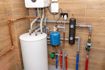A modern gas boiler for natural gas, installed in a boiler room lined with ceramic tiles, 120 liter...