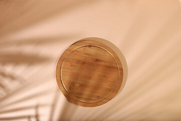 Abstract background with natural wooden podium and long shadows on a pastel wall, empty showcase for display or presentation of cosmetic products, minimal ecology concept,