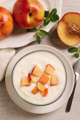 Delicious yogurt with fresh peach on light wooden table, flat lay