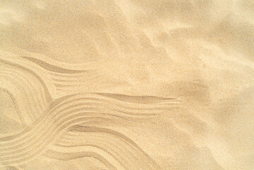Fototapeta na wymiar Drawing of waves on the sand on the beach, sand pattern