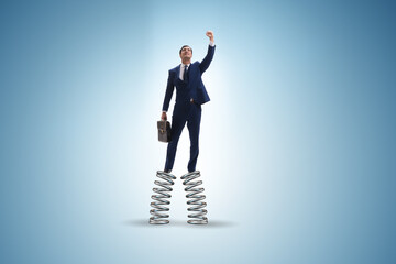 Businessman jumping high on springs