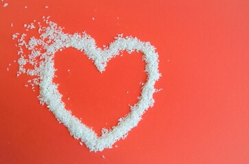 heart on a red background of coconut chips