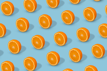 Fresh sliced orange on bright blue background. Fruit pattern, creative summer concept.