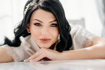 Obraz premium the face of a beautiful brunette bride with long hair and a white hairpin. 