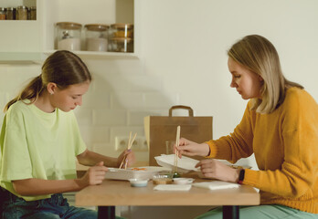 Mom and daughter eat sushi at home.