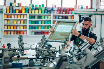 Male worker preparing screen printing film in a workshop