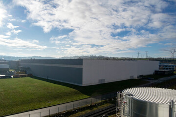 Fototapeta na wymiar Aerial view of a large warehouse in a business park, with a nice sky and some clouds