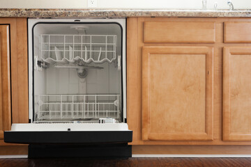 Empty open dishwasher in domestic kitchen