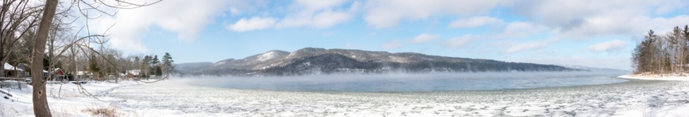 Panoramic view of a winter scene with a lake and ice steam