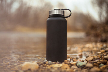 Black water bottle thermos in nature