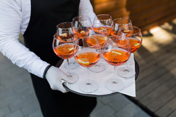 The waiter greets guests, a close-up photo of glasses with the drink Aperol