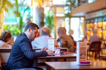 entrepreneur sending an sms with his mobile on a restaurant table