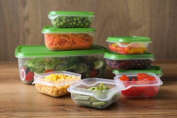 Set of plastic containers with fresh food on wooden  table