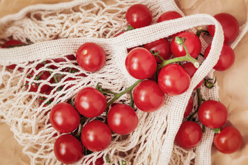 White eco-friendly shopping net mesh bag with tomatoes, top view. Eco zero waste concept, no plastic