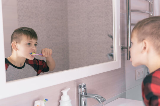 Little Blond Boy Learning Brushing His Teeth In Domestic Bath. Kid Learning How To Stay Healthy. Health Care Concept.