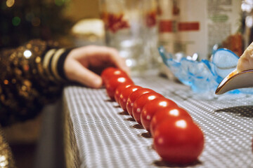 Red tomatoes laid out in a row, a child's hand lays out tomatoes in a row. Selective focus. Cherie