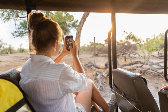 Africa, Namibia, Girl (16-17) in safari vehicle taking pictures
