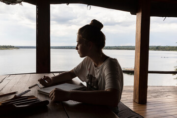 Africa, Zambia, Livingstone, Girl (16-17) relaxing in lodge by Zambezi River