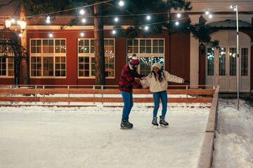 Biracial couple having date at outdoors rink