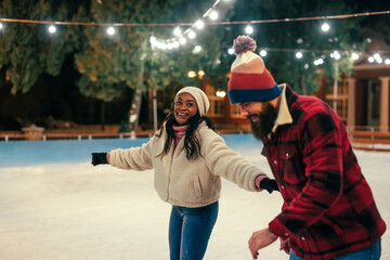 A young couple on an ice skating date - obrazy, fototapety, plakaty