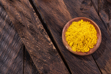 Organic curry yellow powder in the wooden bowl - Healthy food