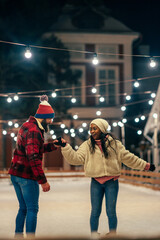 Adult biracial couple on ice skating outdoors
