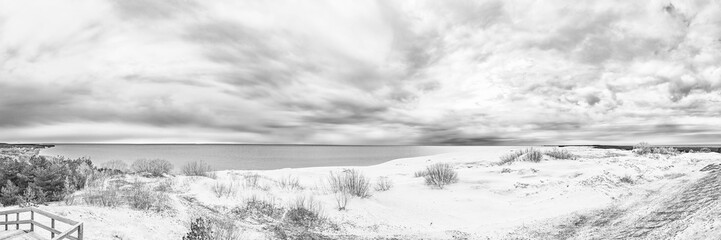Sand dunes of the Curonian Spit in the cloudy weather with the sky covered with clouds on the shore...