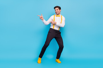 Full length photo of positive cheerful man look indicate fingers empty space isolated on blue color background