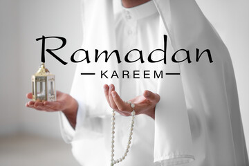 Young Muslim man with lamp and tasbih. Ramadan celebration