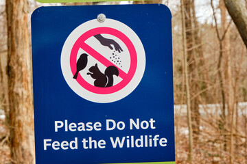 Please do not feed animals sign in a wild outdoor wooden park