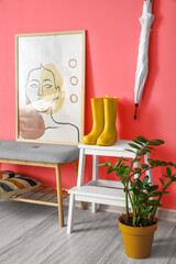 Stepladder stool with gumboots near color wall